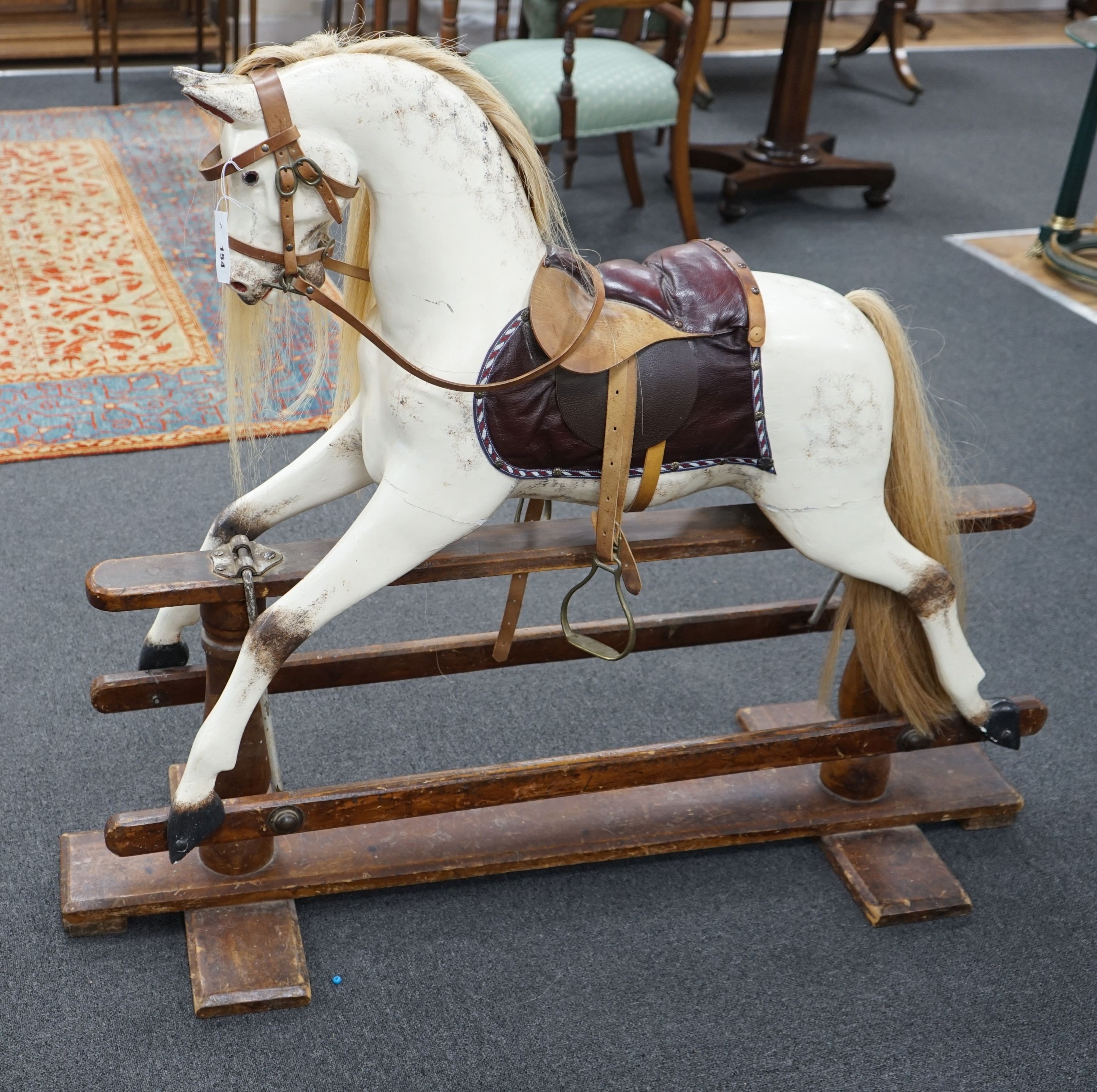 An early 20th century Ayres type dapple grey rocking horse on pine safety frame, width 130cm, height 110cm
